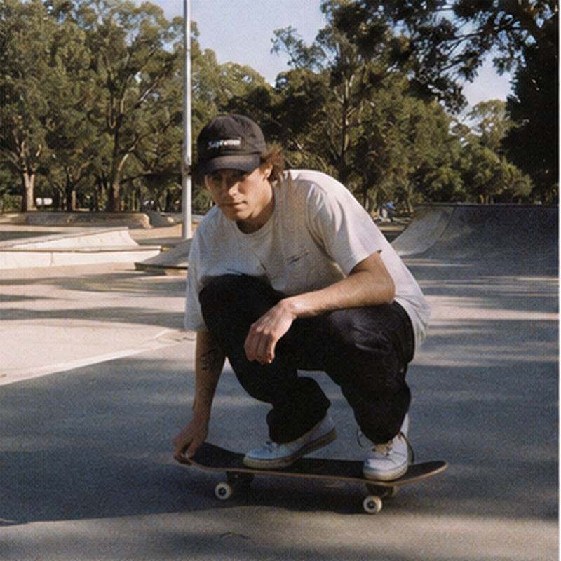 Skater crouching on a board at a skatepark, grainy point and shoot style photo