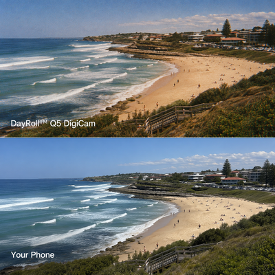 A side-by-side beach scene comparison with the top labeled DayRoll Q5 DigiCam and the bottom labeled Your Phone. The top image shows a bright, vivid coastal beach with blue ocean waves, sandy shore, green dunes, and buildings along the coastline.