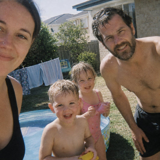 A family mucking around in a backyard pool on a hot day