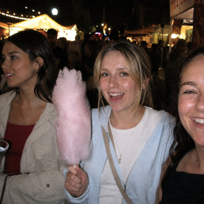 Friends with fairy floss at a night market, warm grain and hard fill light