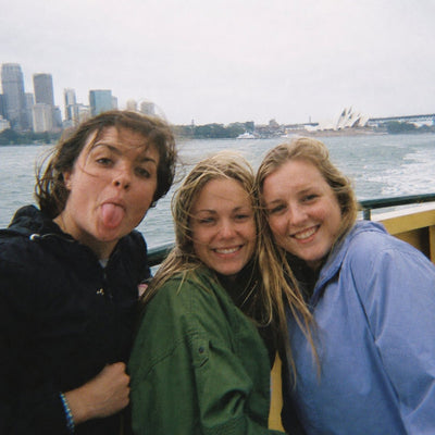 Three friends pulling faces on the ferry with the harbour behind them